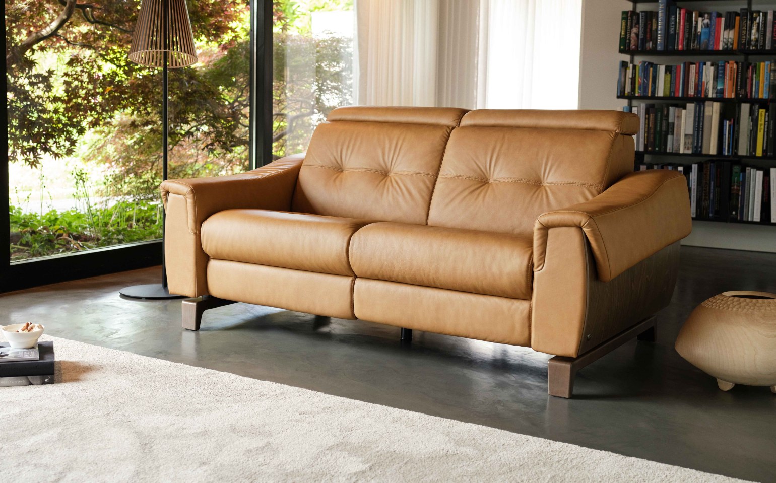 The Stressless Anna Collection combines sleek Scandinavian design with luxurious comfort, making it the perfect choice for modern, multi-functional living spaces. With a choice between power and manual seats side by side, it offers complete control. If you choose the motorised function, the footrest will extend under your feet as the back reclines, while the headrest adjusts, giving you the perfect position for total relaxation. With the manual seat, you can adjust the headrest manually. In a collapsed postion, the sofa appears visually smaller. When raised, it offers excellent head support and transforms a low-back sofa into a high-back, supporting your body in comfort.
With three armrest choices, you can choose one to best suit your needs - a wooden armrest for lovers of Nordic design, and classic leather armrests that blend into any interior. Additionally, the sofa is available with several leg options, allowing you to customise it to your preference.
Available in a wide range of leather and fabric finishes and versatile sofa and corner configurations, Stressless Anna adapts to your lifestyle - whether you're lounging, entertaining, or simply unwinding at the end of the day.
Please note that the Anna collection is not available to order online and we only show a limited number of configurations on our website – if you require a different configuration or would like to order an item from the Anna collection, please contact us.